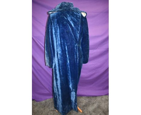 A blue velvet full length opera coat circa 1920s/30s, lined in cream satin or satin blend having detachable hood, faux button
