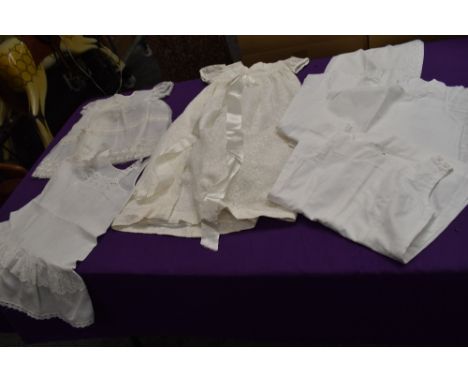 A selection of vintage baby clothes, petticoats and a gown and bonnet.