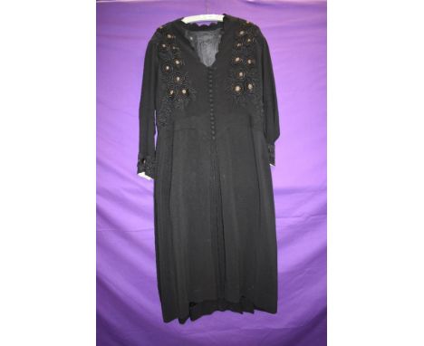 A late 30s/early 40s black crepe day dress having soutache braiding with gold accents,self covered button front, decent size,