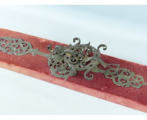 A LARGE 17TH CENTURY WROUGHT IRON DOOR HANDLE / KNOCKER WITH FOLIATE SCROLL AND MASK ENGRAVED BACKPLATES, LATER MOUNTED ON A 