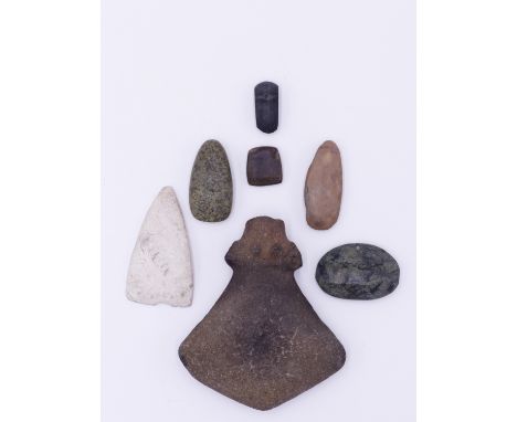 AN CARVED STONE AXE, FIVE WORKED STONE TOOLS AND GREEN STONE PENDANT. THE AXE 13.5 CM LONG (7) 