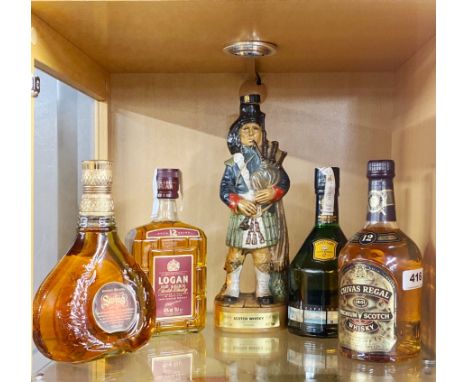 Four bottles of good whiskey and an empty ceramic bagpiper bottle.
