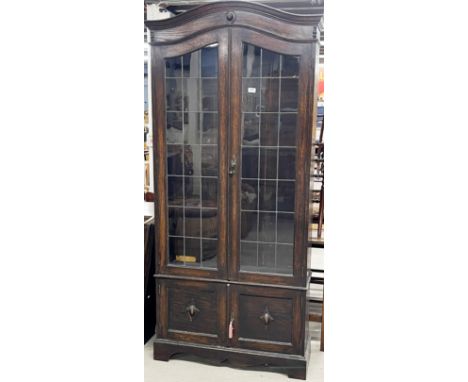 A 1920's carved oak bookcase with leaded glass doors, W. 93cm. H. 201cm.