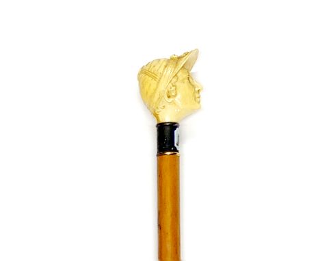 A carved jockey's head bone handled walking stick with enamelled ferule, overall L. 91cm.