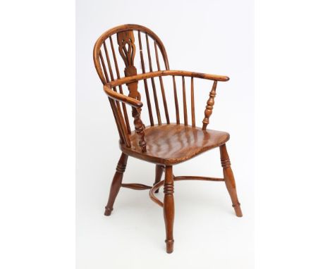 A YEW WINDSOR ARMCHAIR, of low hoop back form, 19th century, with shaped and pierced splat, baluster turned arm supports, elm