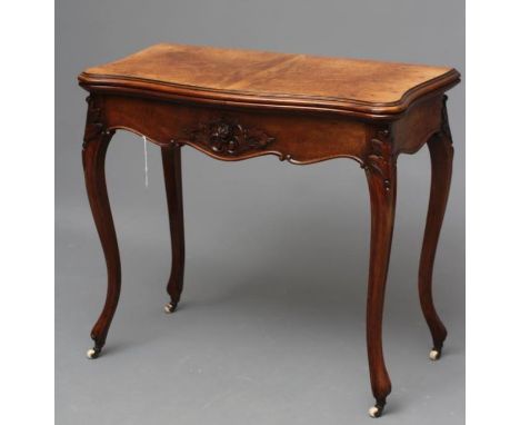 A VICTORIAN FOLDING CARD TABLE of serpentine form in the French taste, the quarter veneered moulded edged burr top opening to