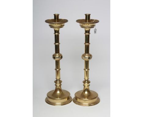 A LARGE PAIR OF ARTS AND CRAFTS BRASS CANDLESTICKS, the turned socket with moulded flared drip pan, ring turned and knopped s
