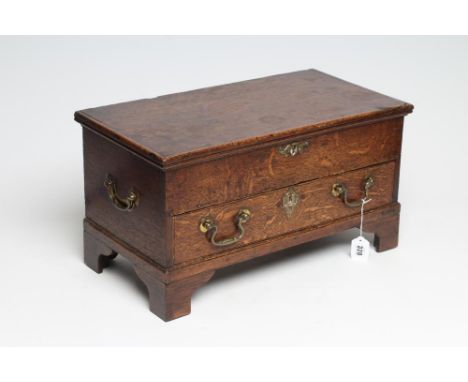 AN OAK TABLE BOX, early 19th century, the oblong hinged lid opening to a void interior, drawer below with brass drop handles,