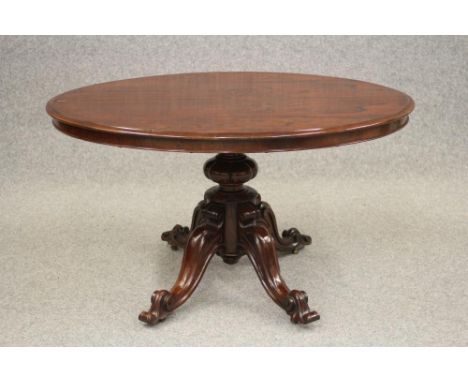 A VICTORIAN ROSEWOOD LOO TABLE, the moulded edged oval tilt top with plain frieze, raised on turned melon stem and scrolled q