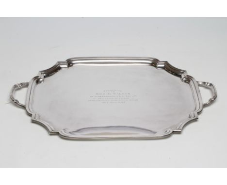 A SILVER TWO HANDLED TEA TRAY, maker's mark HP &amp; S, Birmingham 1934, of oblong form with re-entrant corners and plain ree