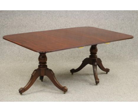 A WILLIAM IV MAHOGANY TWIN PEDESTAL DINING TABLE with a single leaf, the reeded edged rounded oblong top raised on baluster t