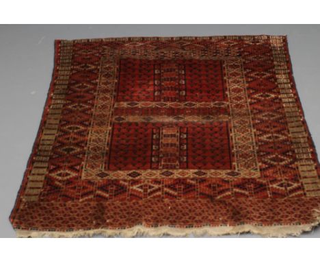 AN AFGHAN RUG, the quartered burgundy field of candelabra design, with a geometric surround with mihrab, geometric main borde