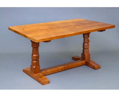 A ROBERT THOMPSON ADZED OAK REFECTORY TABLE, 1950's, of rounded oblong form raised on turned faceted and block end supports w