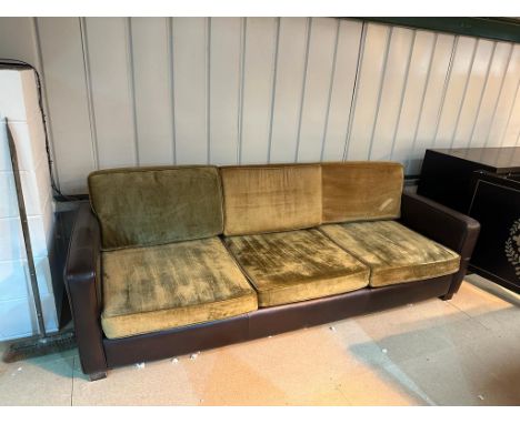 Slender and simple tuxedo style three-cushion sofa in gold velvet upholstery the frame in brown leather 247 x 90 x 85cm