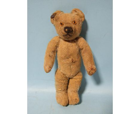 A small early-20th century Chad Valley teddy bear with blank ear button, blonde mohair, replaced glass eyes, vertically-stitc