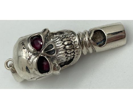 A modern 925 silver whistle in the form of a skull with red stone set eyes &amp; hanging bale. Marked 925 and sterling to rev