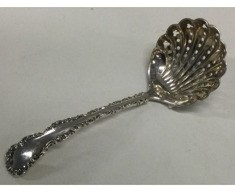 A decorative silver pierced sifter spoon with chased border. Sheffield 1906. By Henry Wilkinson. Approx.24 grams. Est. £20 - 
