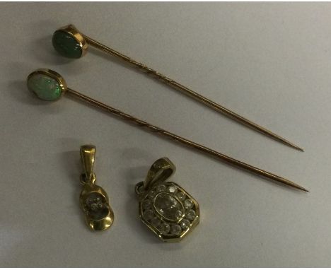 Two gold stick pins together with two gold pendants. Approx. 4 grams. Est. £30 - £50.