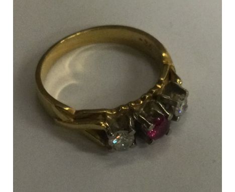 An attractive ruby and diamond three stone ring in 18 carat gold claw mount. Approx. 5 grams. Est. £200 - £300.