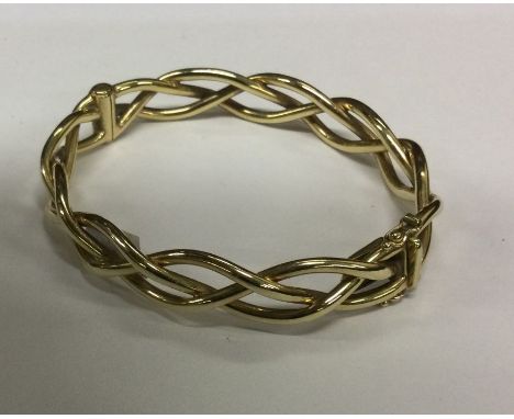 A 9 carat twist bangle with concealed clasp. Approx. 18 grams. Est. £200 - £300.