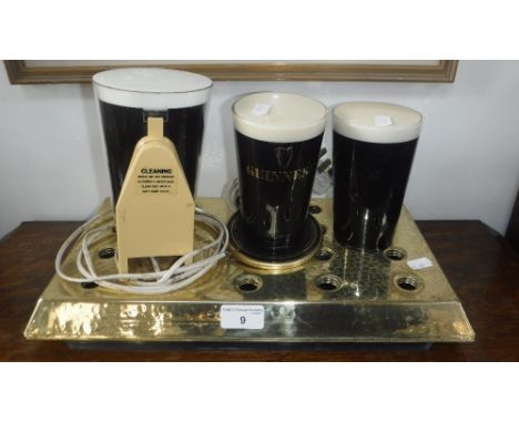 GUINNESS: TWO VINTAGE ILLUMINATED PINTS OF GUINNESS, to sit in front of beer pumps, another similar and a brass 'Guinness' dr