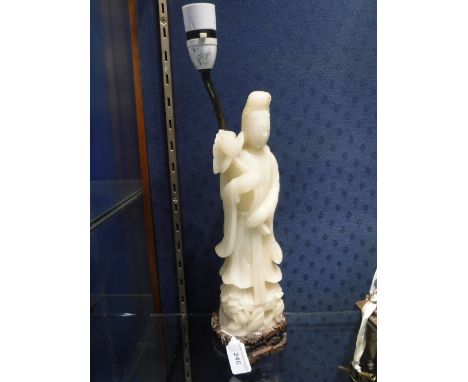 A 'JADE' FIGURE OF AN ORIENTAL DEITY standing on a carved wooden base, fitted as a table lamp