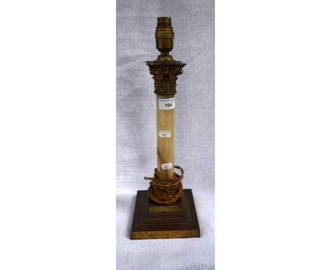 AN EARLY 20TH CENTURY BRASS TABLE LAMP with Corinthian capital above an onyx column