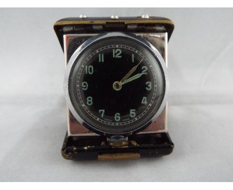An Art Deco styled purse watch or small travelling clock, black and gold case containing a 28mm black dial movement with Arab