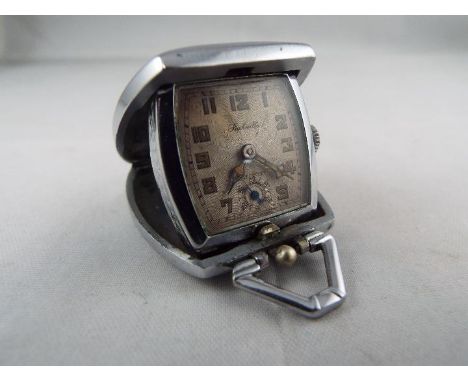 An Art Deco styled cushion form purse watch/ clock, the case with engine turned decoration, silvered dial with subsidiary sec