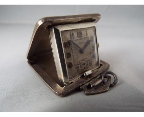 An Art Deco cushion styled purse watch or small travelling clock, silver case with 925 import assay marks for London and capi