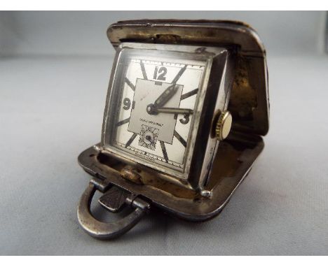 A small silver purse watch/ clock in a 36mm square cushion form case with brown leather covering, Birmingham assay marks, the