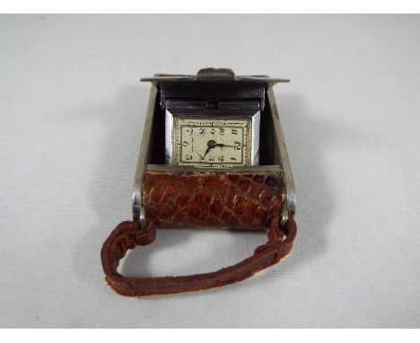 A small purse watch/ travelling clock, white metal and brown leather in the form of an early camera, made in France, Art Deco