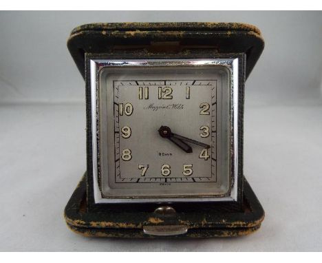 A good Mappin & Webb 8-day travelling clock in a folding green leather case, silvered dial marked Mappin & Webb, the clock ti