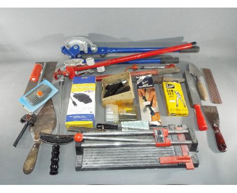 Two sets of pipe benders with a quantity of hand tools including a tile cutter, trowel, float, sharpening stone,saw sharpener