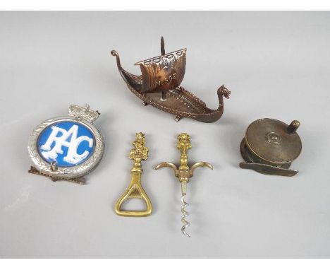 A brass 'Imp' bottle opener and a corkscrew, vintage fishing reel, a vintage RAC badge and a model depicting a Viking longboa