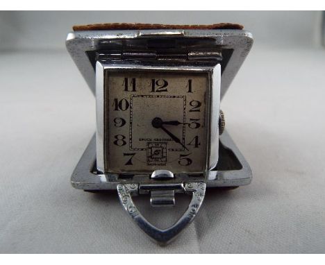A small purse watch/ clock in a 36mm square cushion form case with brown shagreen or leather covering, the watch ticks when w