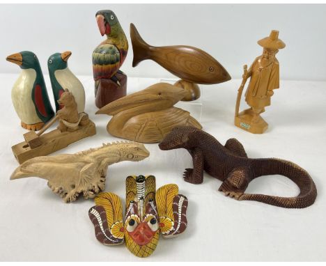 A collection of carved wooden animals and figures, some painted. To include parrot, pelican, lizards, Russian bear, penguins 