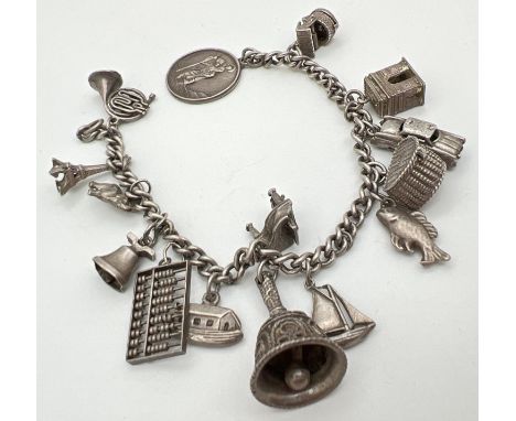 A vintage white metal curb chain bracelet with 15 silver and white metal charms. No clasp to bracelet. Charms include piano, 