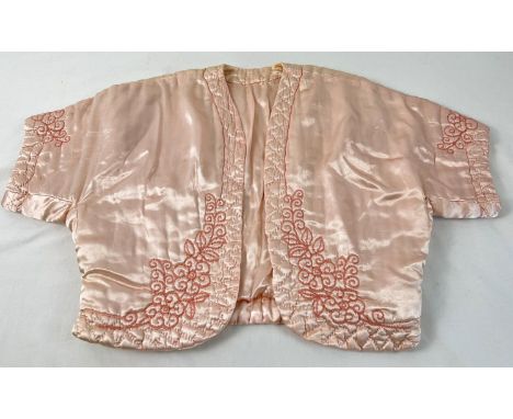 A vintage pink satin quilted bed jacket with embroidered detail. 