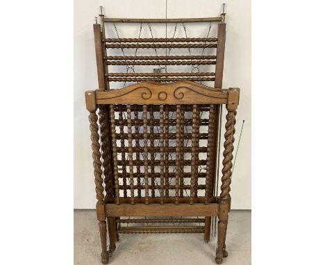 A vintage dark wood cot with barley twist posts and bobbin style spindles. 