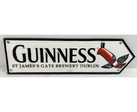 A painted cast iron Guinness wall plaque arrow with toucan detail. Approx. 38cm long. 
