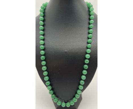 A 26" string of apple green jade beads, knotted between each bead. Beads approx. 1cm diameter. 