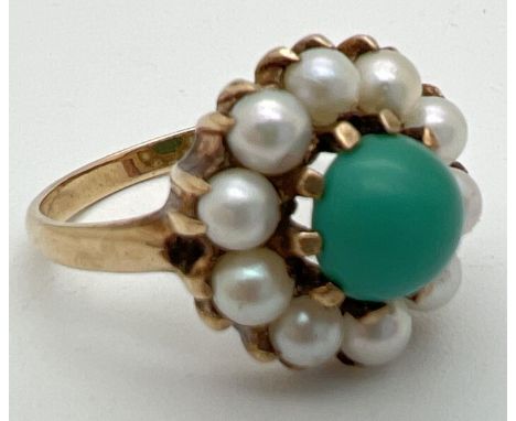 A vintage 9ct gold dress ring set with turquoise and pearls. Central round cabochon of blue turquoise surrounded by 10 white 