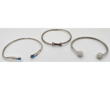 3 silver bangles. A multi strand wire style bangle, a torque style bangle with Greek key detail set with opal stone to each e