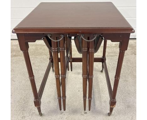 A vintage dark wood nest of 3 tables with 2 small drop leaf folding tables and larger square shaped table. Raised on 4 small 