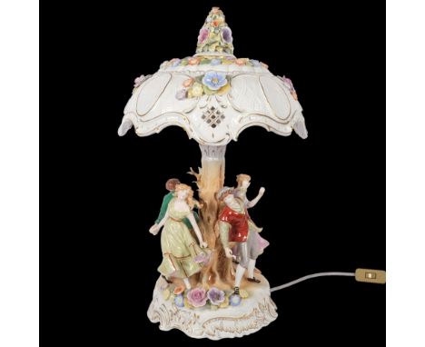 A porcelain table lamp with matching shade encrusted with flowers, the base supported by 4 dancing figures, H54cm 