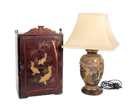 A Japanese ceramic table lamp with moulded and painted design, and shade, 50cm, and an Oriental lacquer cabinet, with gilded 