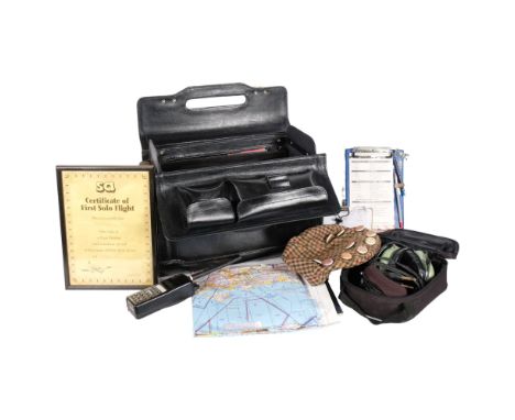 A pilot's leather flight bag and contents, including manuals, radio, headphones etc, a framed certificate of first solo fligh