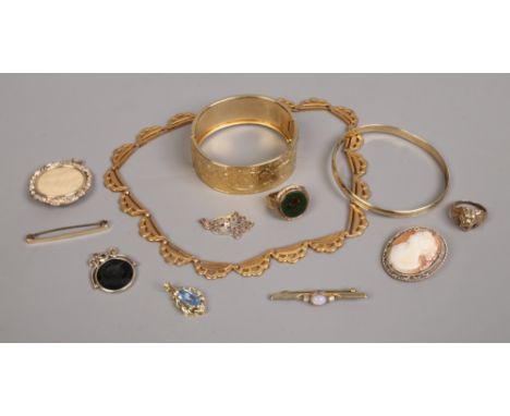 A quantity of yellow metal jewellery including bangles cameo and bar brooches, scarf clip, pendants etc.