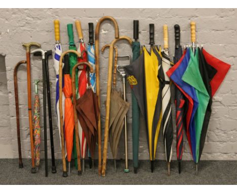 A collection of umbrellas, walking sticks and a shooting stick.